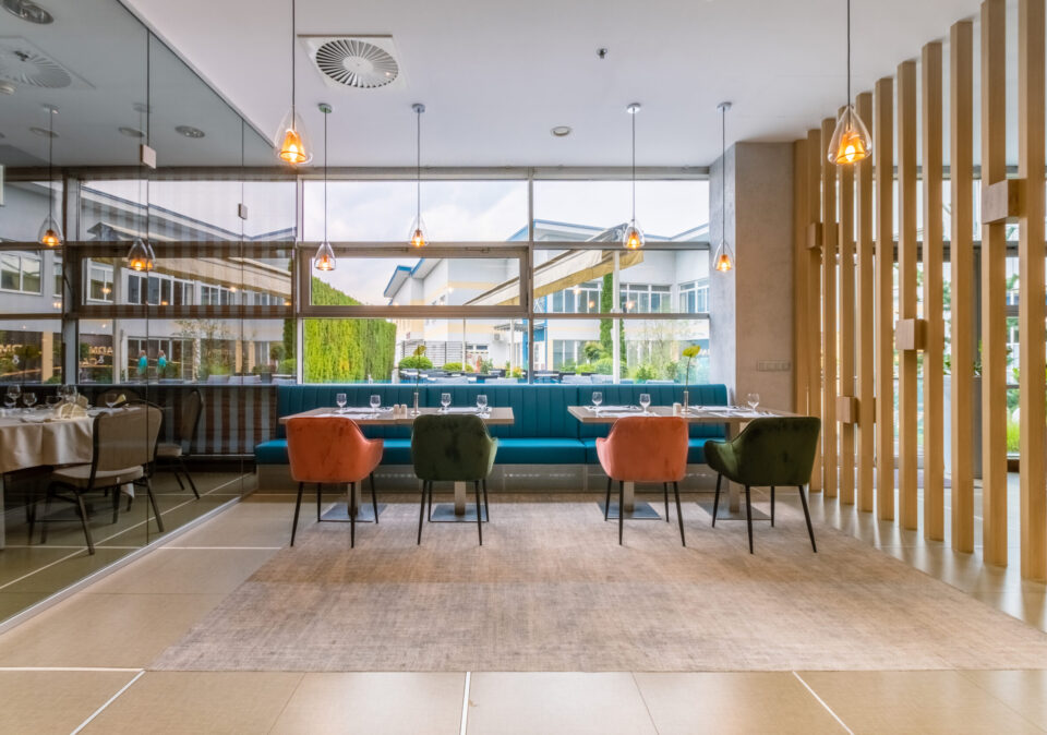 Bright Cosmopolitan Restaurant interior with garden views.