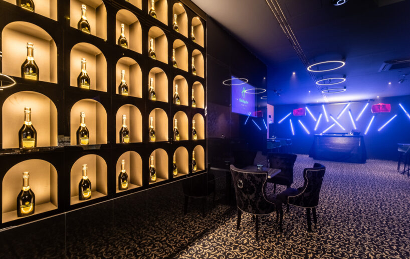 HI.5 Night Bar stage and illuminated bottle wall.