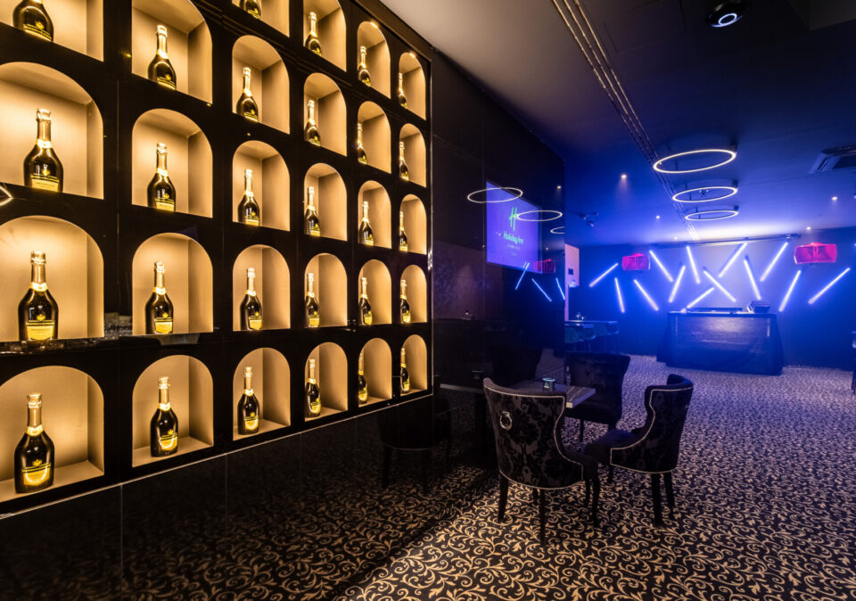 HI.5 Night Bar stage and illuminated bottle wall.