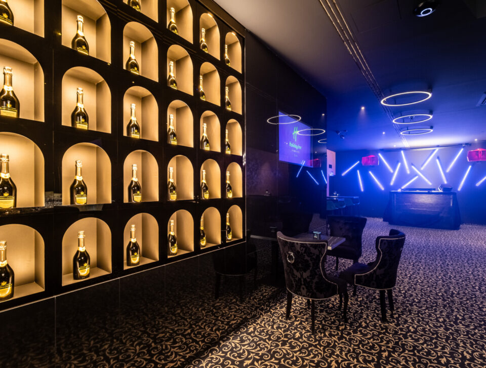 HI.5 Night Bar stage and illuminated bottle wall.