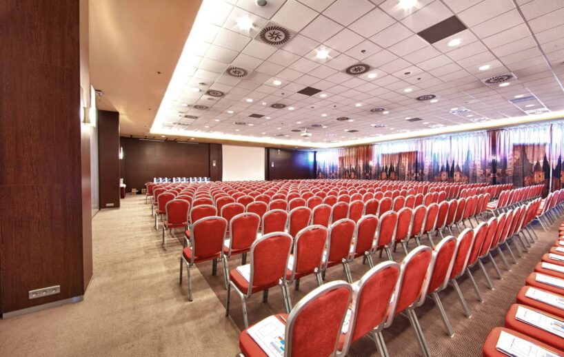 Millennium conference hall with red theatre seating.